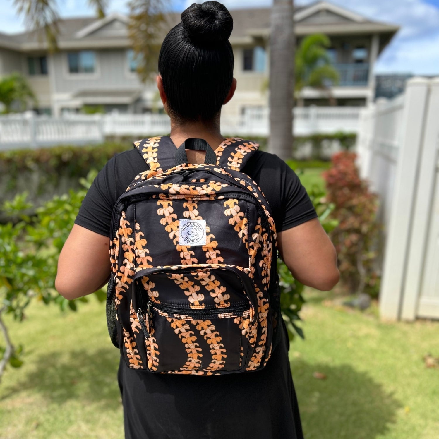 Backpack by Puakenikeni Designs, in the best selling and favorite pua kenikeni lei design, Kaulua, on model