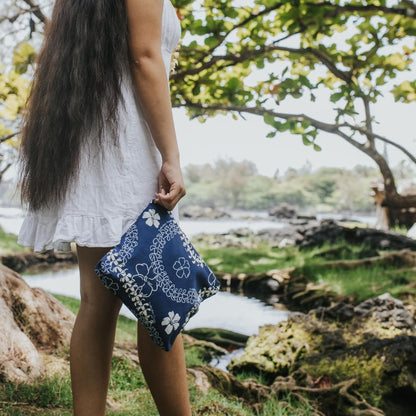 puakenikeni lei canvas zipper pouch with zipper in blue from Puakenikeni Designs held by model