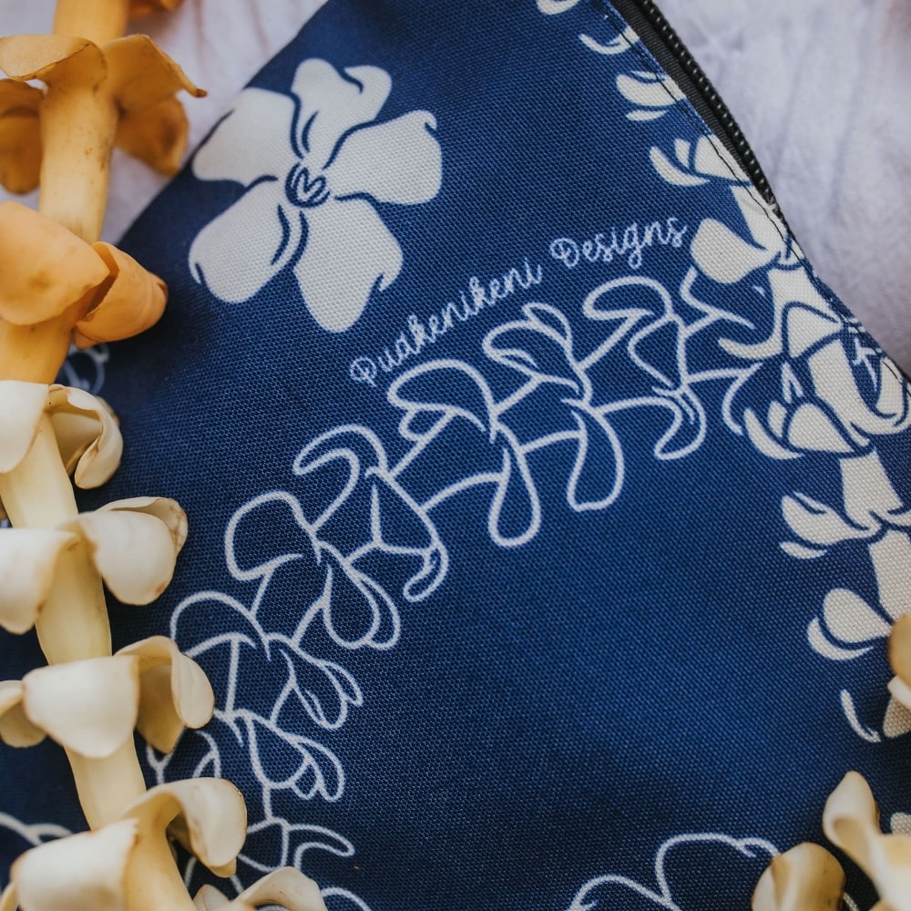 puakenikeni lei canvas zipper pouch with zipper in blue from Puakenikeni Designs close up of front and brand