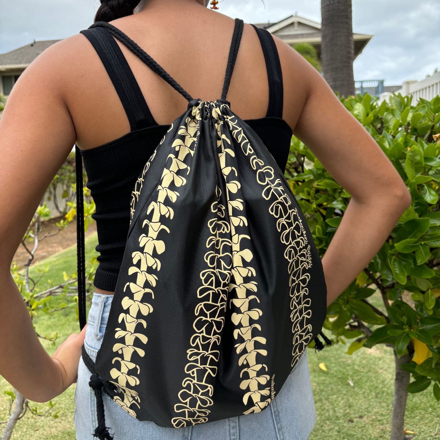 cinch drawstring backpack with pua kenikeni lei from Puakenikeni Designs full view on model