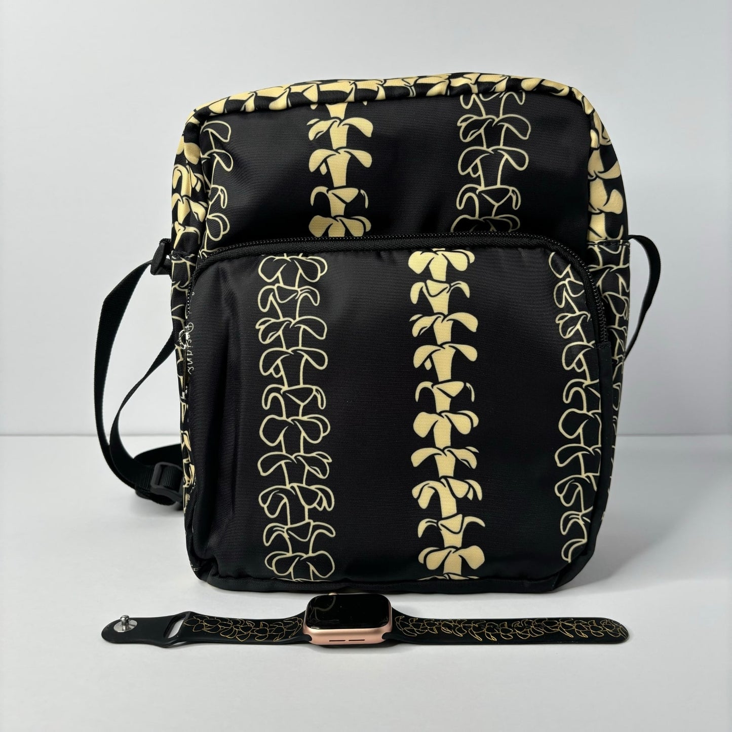 Crossbody bag by Puakenikeni Designs, in black with the best-selling pua kenikeni lei design, Kaulua; for women, moms, teenage girls, for travel and school Beige Lei Design next to Apple Watch