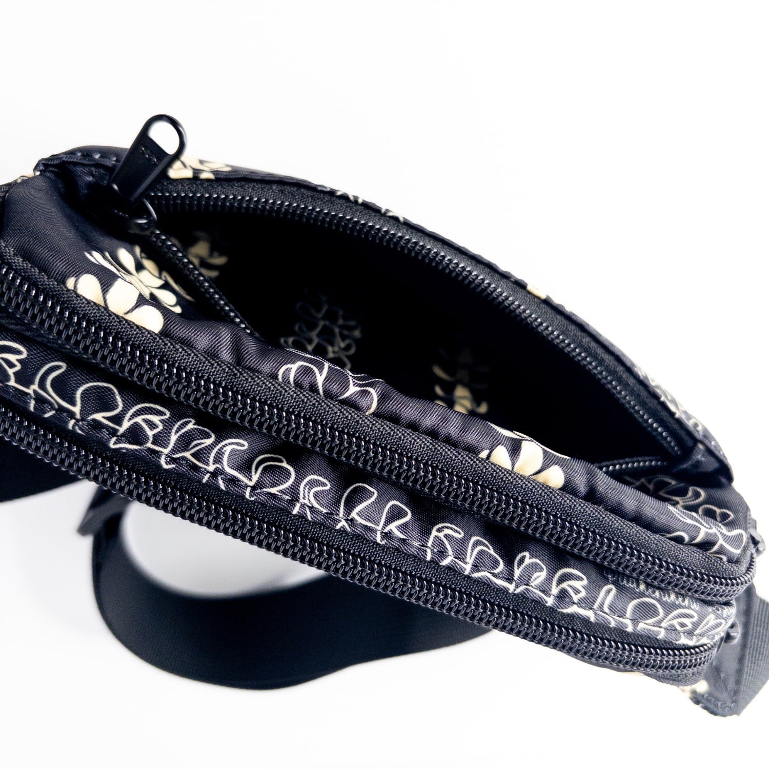 fanny pack, waist bag, belt bag, chest bag, hip pack, crossbody in pua kenikeni lei on black from Puakenikeni Designs top view front pocket