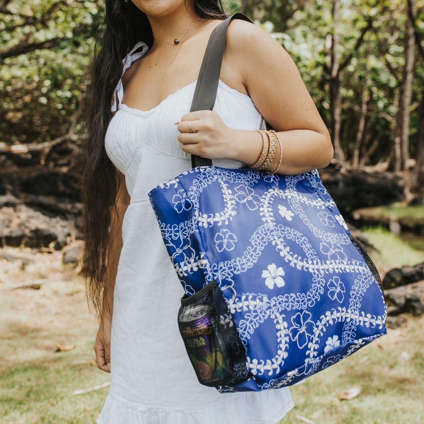 holoholo bag with pua kenikeni lei and flowers in blue from Puakenikeni Designs on model close up