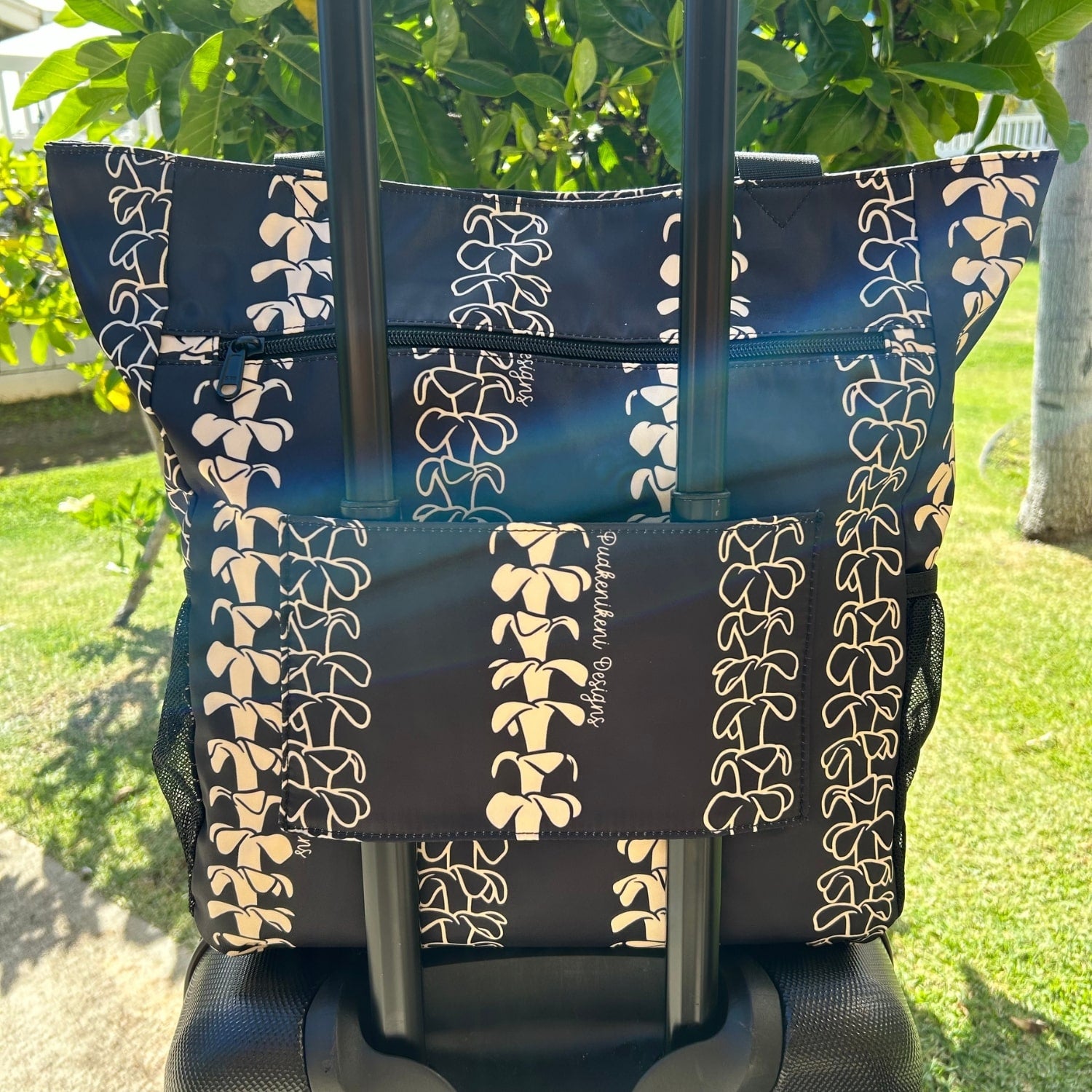 Holoholo Bag for travel from Puakenikeni Designs - use for beach, diaper bag, handbag, hula bag on a rolling suitcase back view