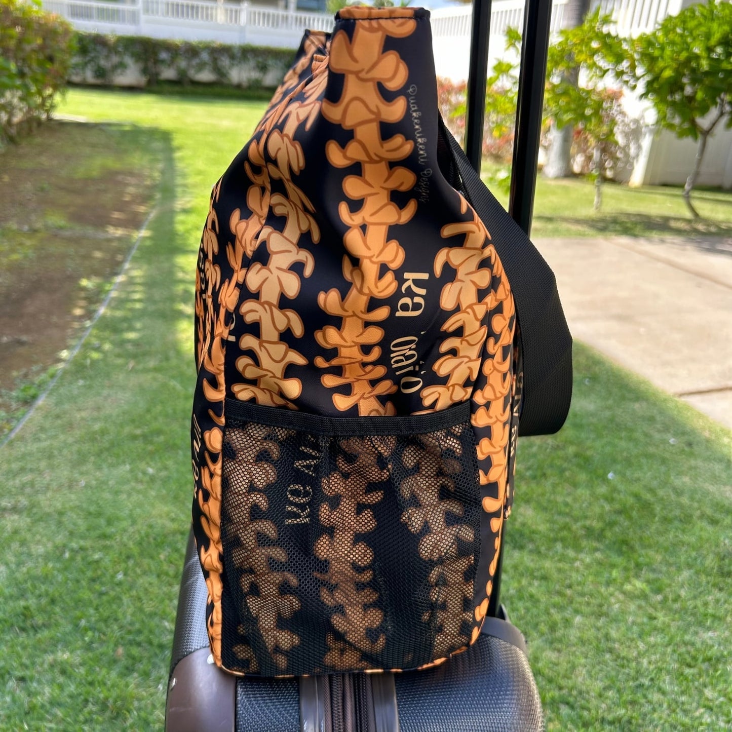 Holoholo Bag for travel, beach, hula, with puakenikeni lei Christian Faith collection by Puakenikeni Designs on a rolling suitcase side view