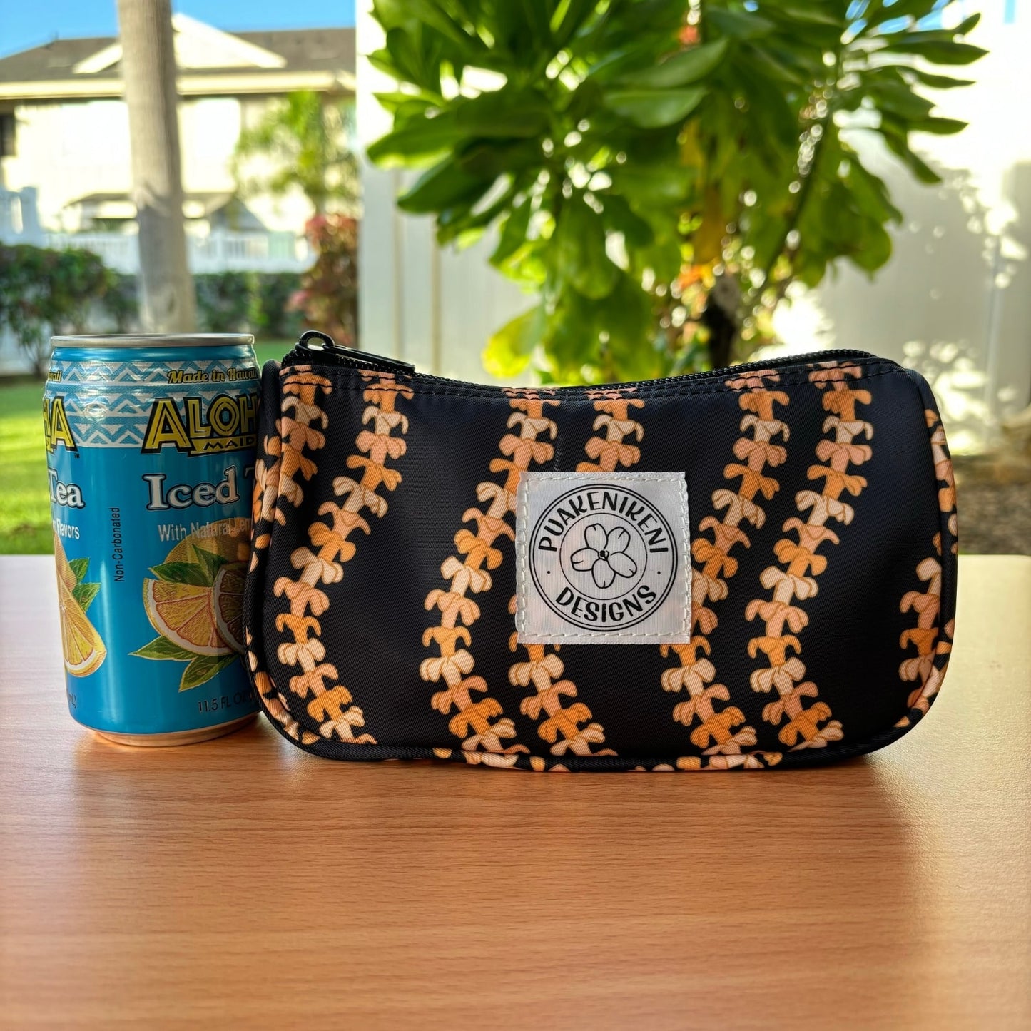 grab and go set includes mini zipper pouch and wristlet key fob in kaulua black orange lei - from Puakenikeni Designs - mini zipper pouch next to juice can to show size comparison