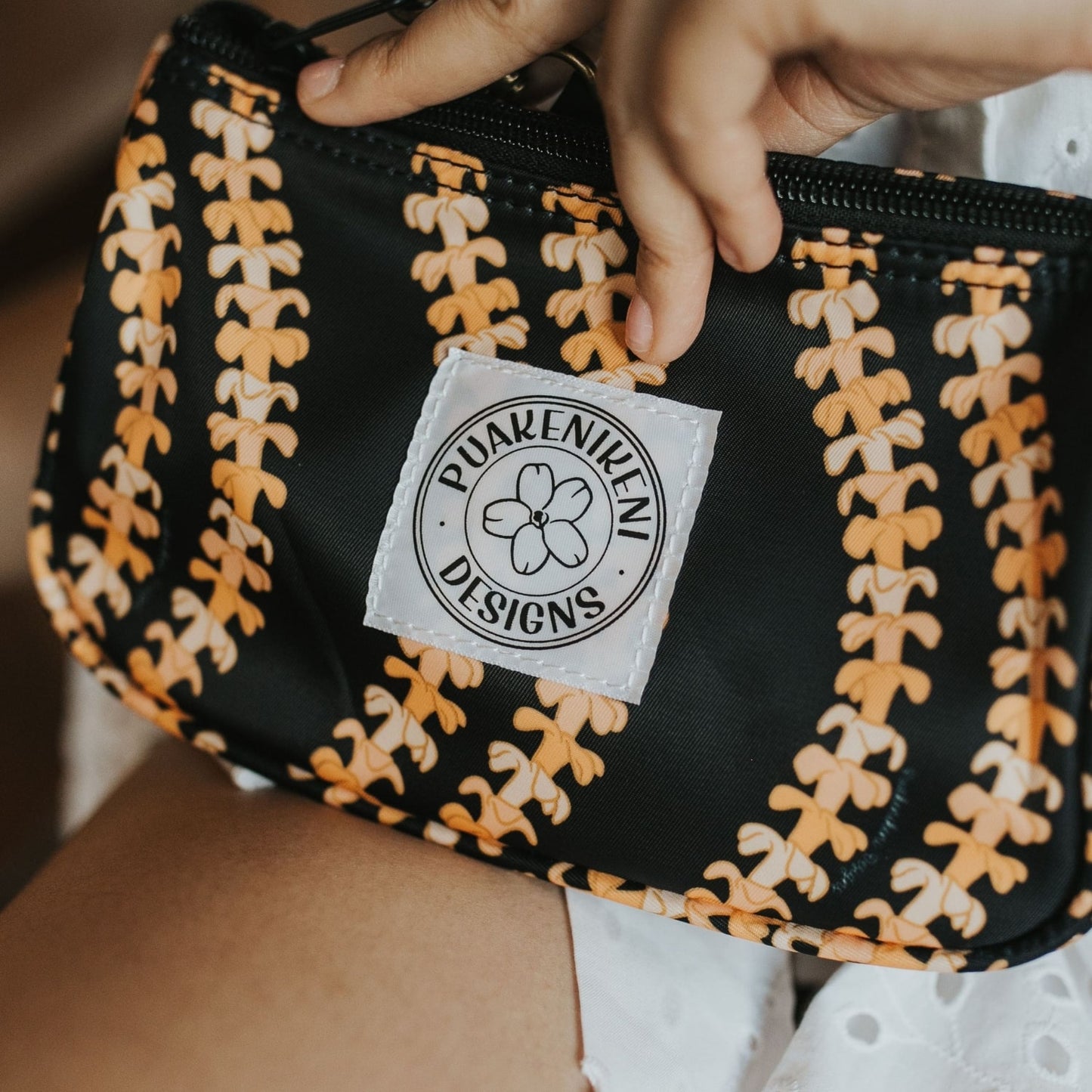 grab and go set includes mini zipper pouch and wristlet key fob in kaulua black orange lei - from Puakenikeni Designs - model holding