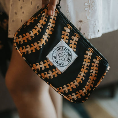 Mini Zipper Pouch - make-up bag, clutch, wristlet, with puakenikeni lei design from Puakenikeni Designs - model holding on the side