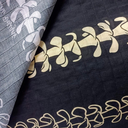 hawaiian baby muslin swaddle blanket with puakenikeni lei - black close-up