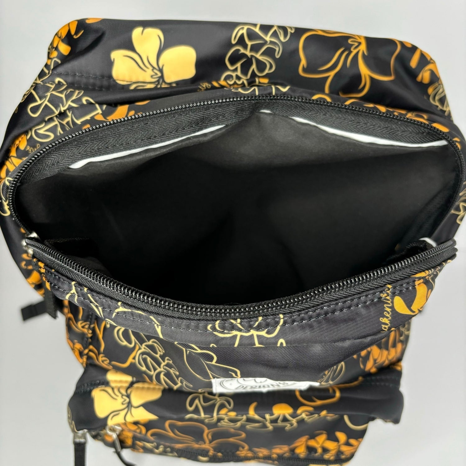 backpack for school, travel, diaper bag, with pua kenikeni lei, black and orange from Puakenikeni Designs middle pocket