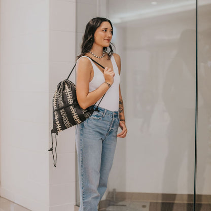 cinch drawstring backpack with pua kenikeni lei from Puakenikeni Designs Beige Lei on model's shoulder