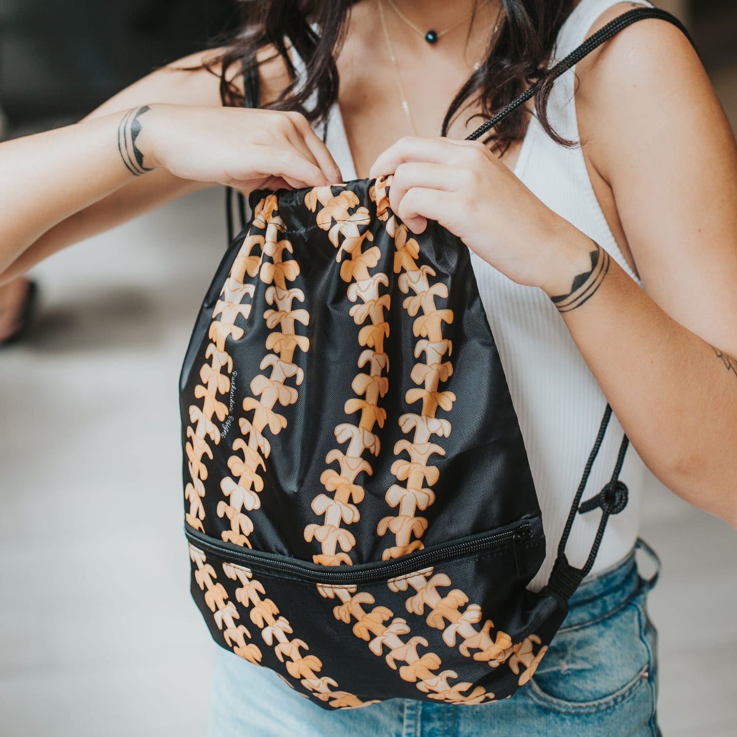 cinch drawstring backpack with pua kenikeni lei from Puakenikeni Designs Kaulua Black close up front view