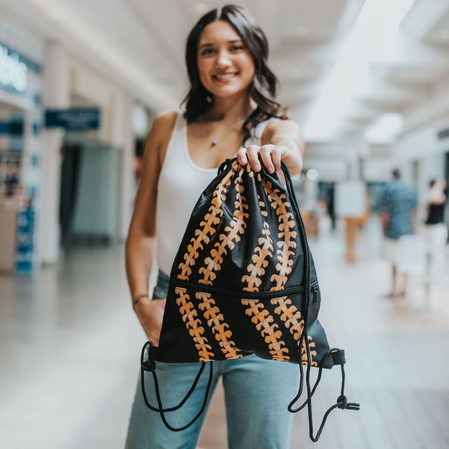 cinch drawstring backpack with pua kenikeni lei from Puakenikeni Designs Kaulua Black model holding