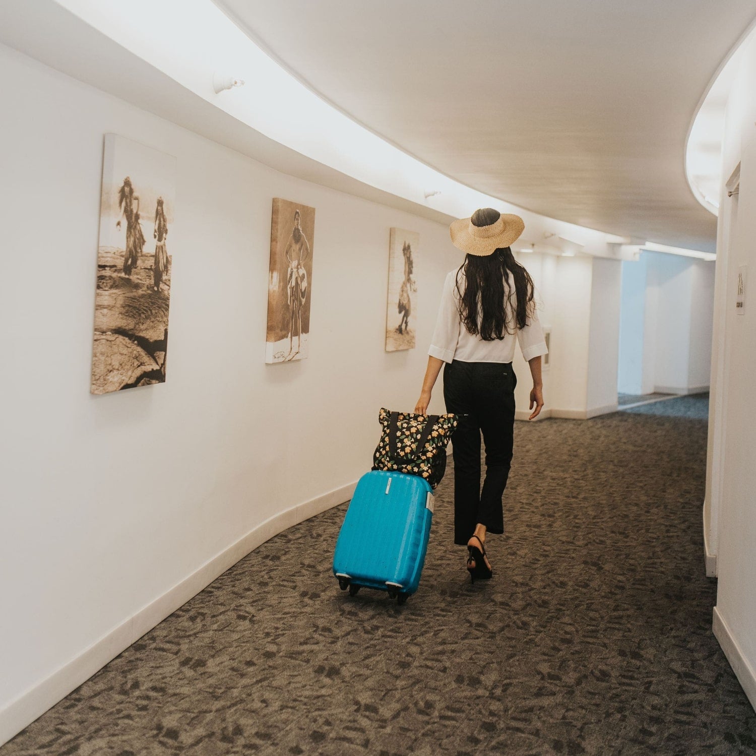 Holoholo bag with pua kenikeni flowers and leaves from Puakenikeni Designs model traveling walking with luggage down hotel lobby