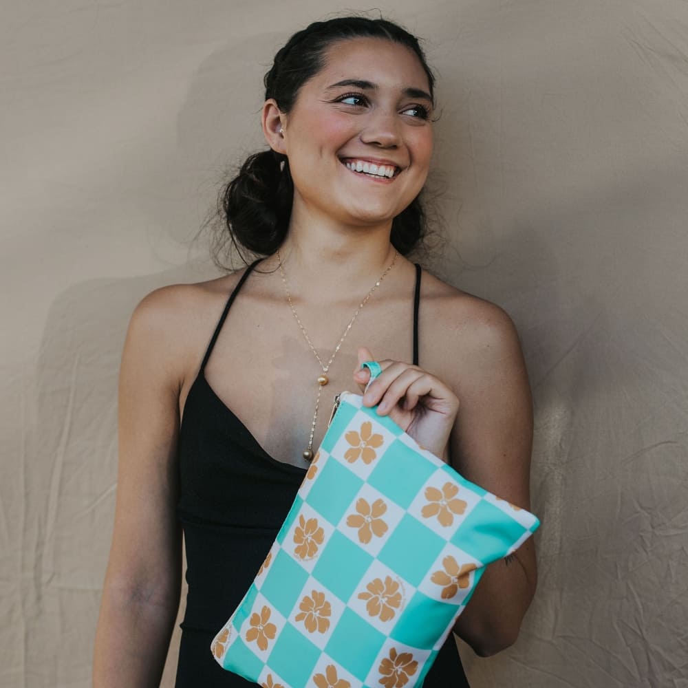 holoholo zipper pouch in turquoise checker from Puakenikeni Designs model holding