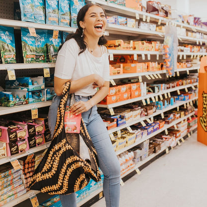 puakenikeni lei large foldable reusable shopping bag - kaulua black - from Puakenikeni Designs - model having fun using at grocery store