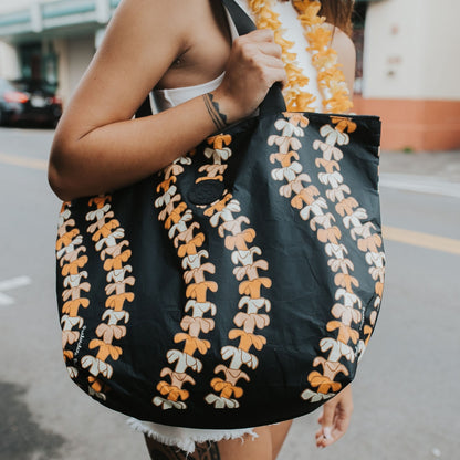 medium tyvek tote kaulua black with pua kenikeni lei from Puakenikeni Designs close up on model