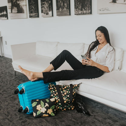 Travelers set with Holoholo Bag and Large Canvas Zipper Pouch with pua kenikeni flowers and leaves from Puakenikeni Designs model relaxing on couch in hotel lobby during travel